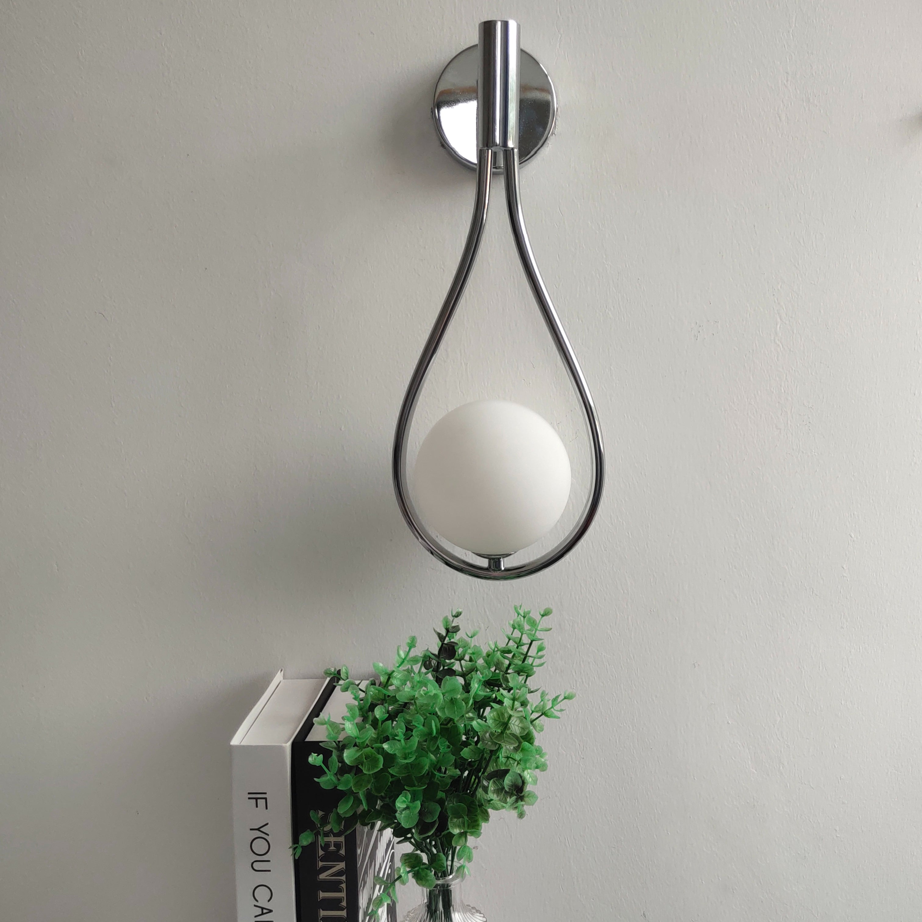 Livi II black Nordic wall sconce mounted on a dark papered wall in a hallway
