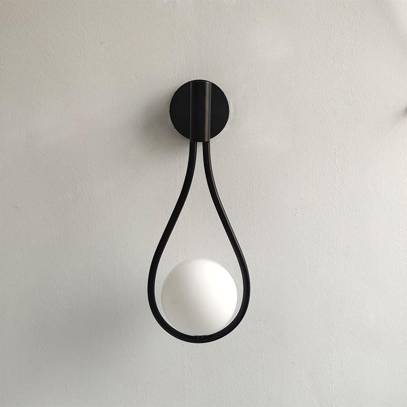 Livi gold Nordic wall sconce mounted beside a bed in a minimalist bedroom