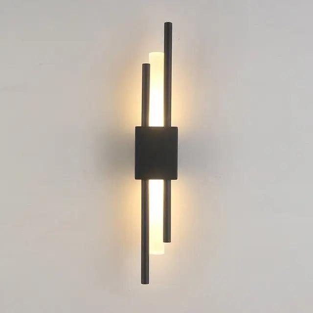 Adan matte black articulated metal wall lamp mounted in a bedroom beside a headboard