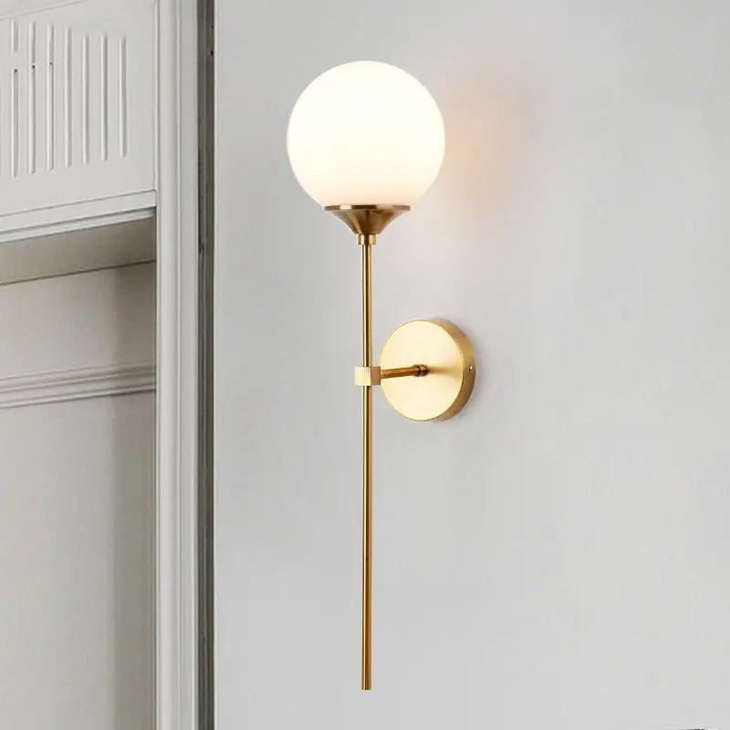 Annika amber glass ball wall sconce mounted in a dining room beside a mirror