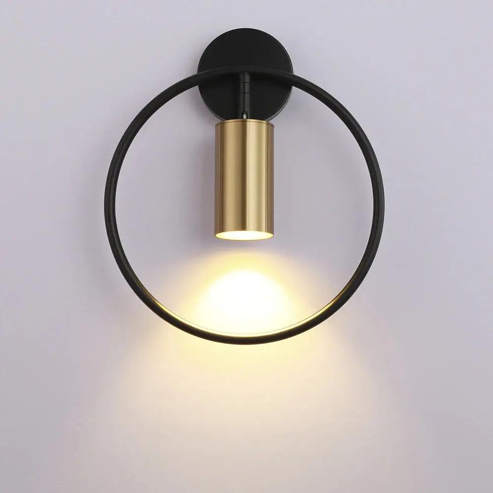 Benthe gold post-modern wall sconce on a white wall in a living room