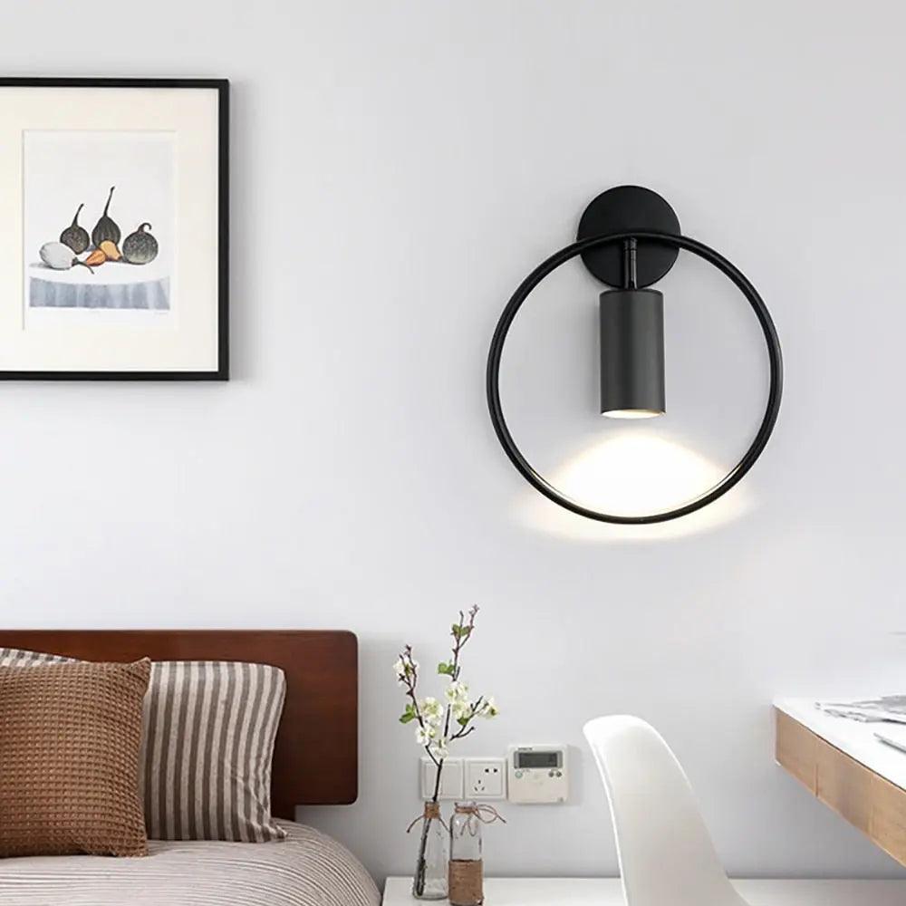 Benthe gold post-modern wall sconce on a white wall in a living room