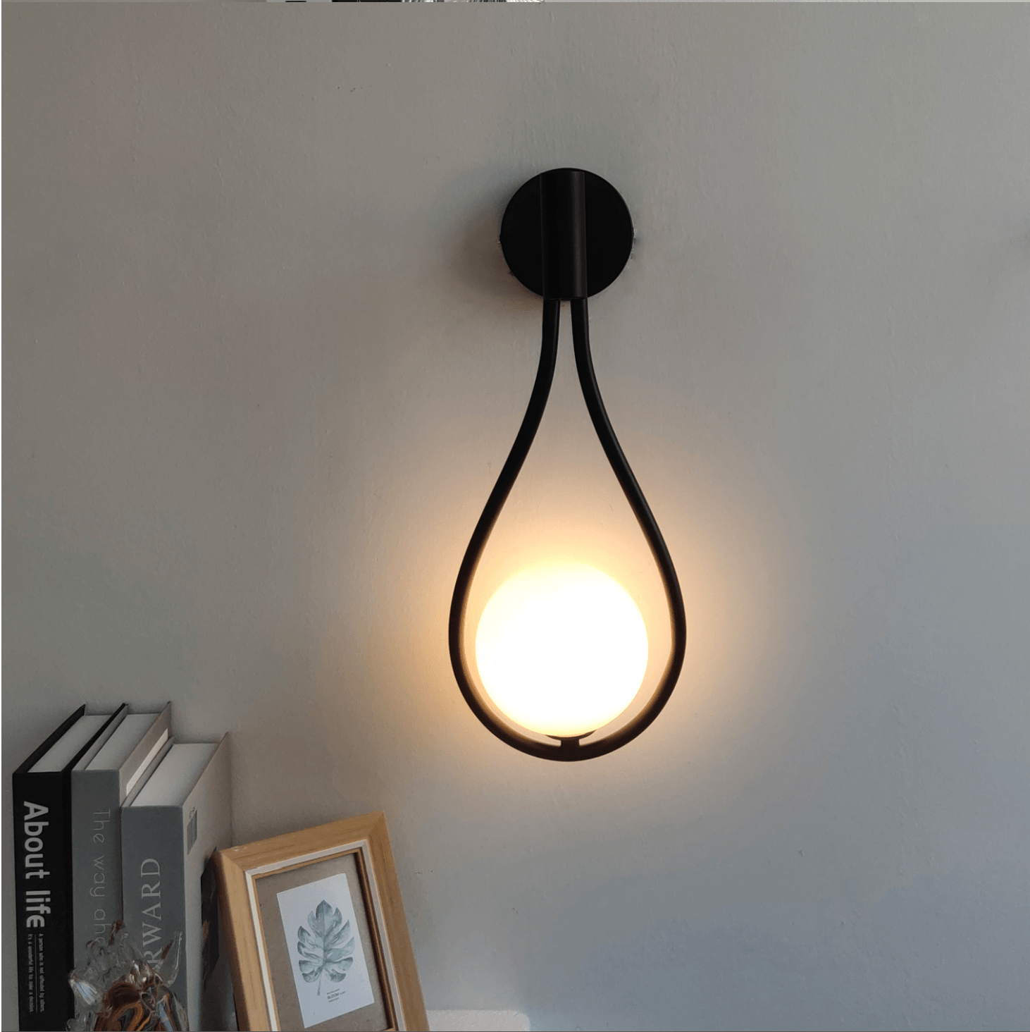 Livi gold Nordic wall sconce mounted beside a bed in a minimalist bedroom