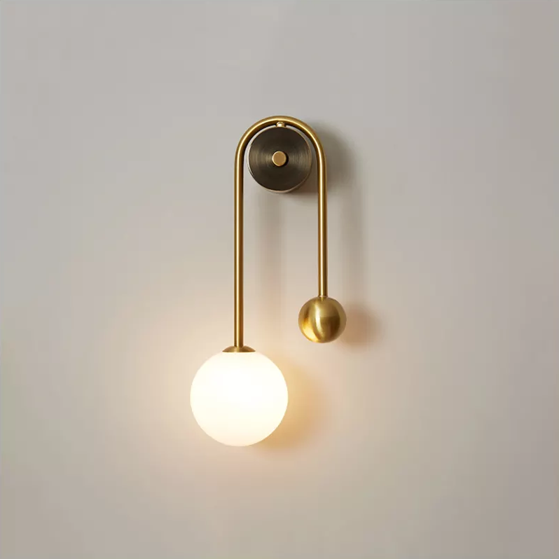 Amalia twin-arm gold Nordic wall sconce with white glass shades flanking a dining room mirror