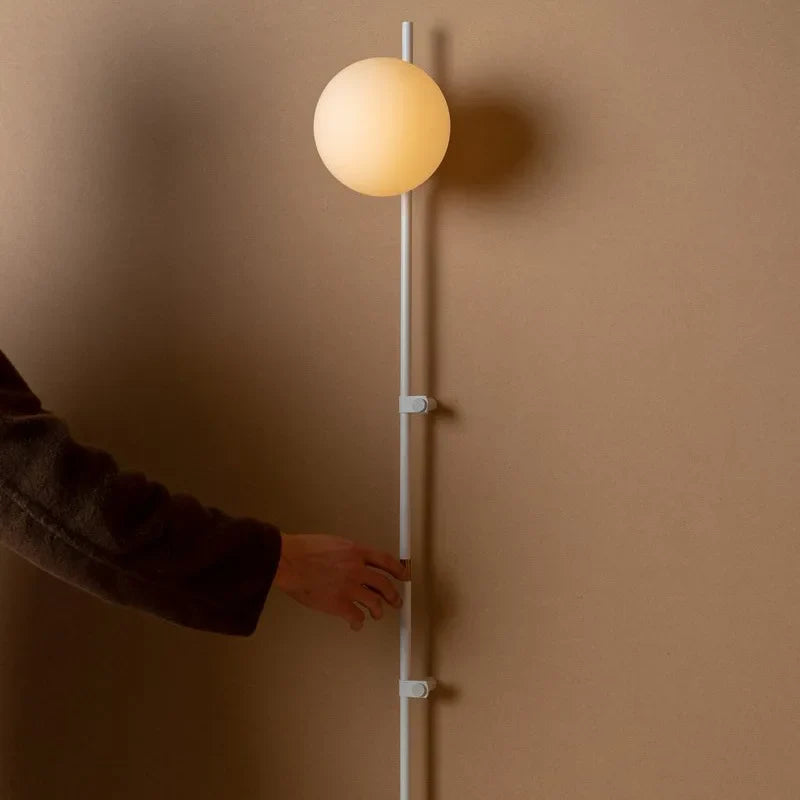 Sol Nordic plug-in wall sconce in black mounted in a living room beside a sofa