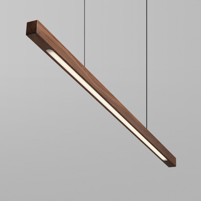 Lindö pine wood dining pendant light hanging low above a long dining table in a Nordic interior