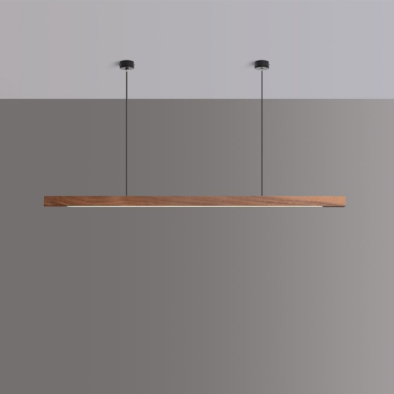 Lindö pine wood dining pendant light hanging low above a long dining table in a Nordic interior