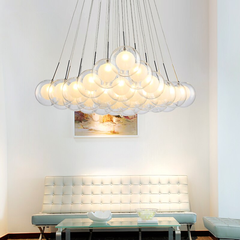 Cluster glass ball chandelier with multiple white glass spheres hanging above a dining table