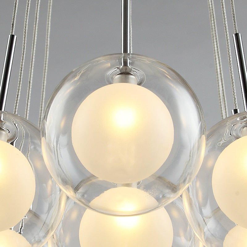 Cluster glass ball chandelier with multiple white glass spheres hanging above a dining table