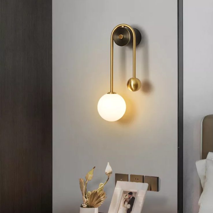 Amalia twin-arm gold Nordic wall sconce with white glass shades flanking a dining room mirror