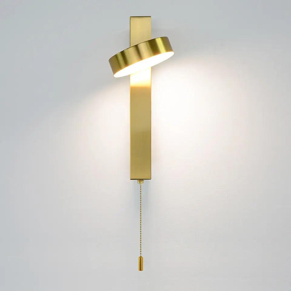 Lif gold rotating wall sconce angled upward for ambient lighting in a living room