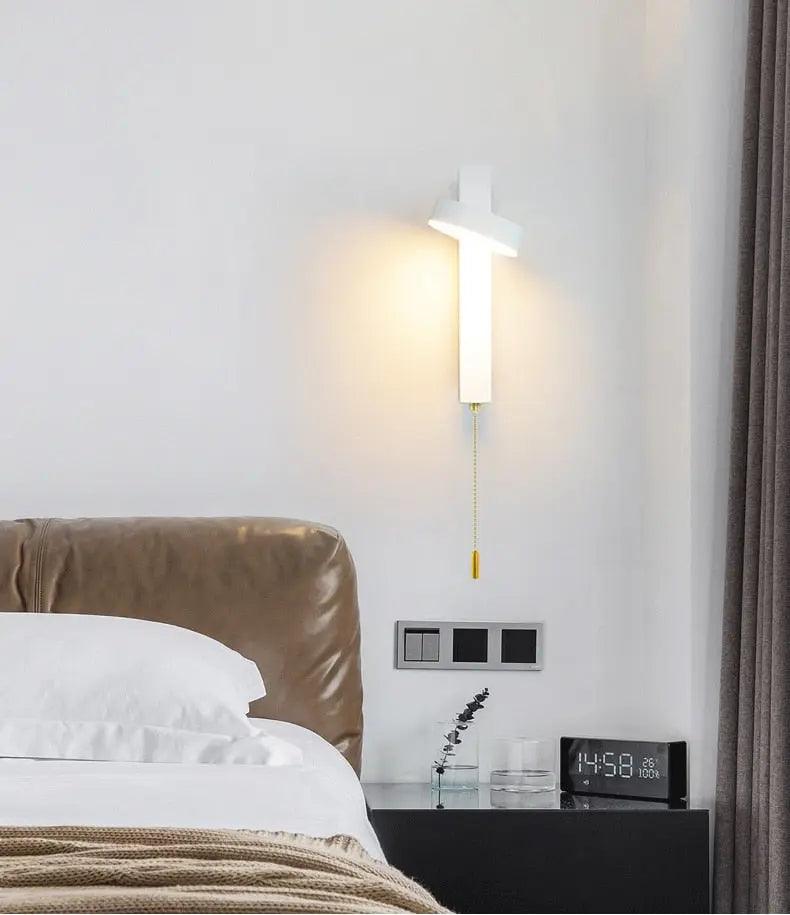Lif gold rotating wall sconce angled upward for ambient lighting in a living room
