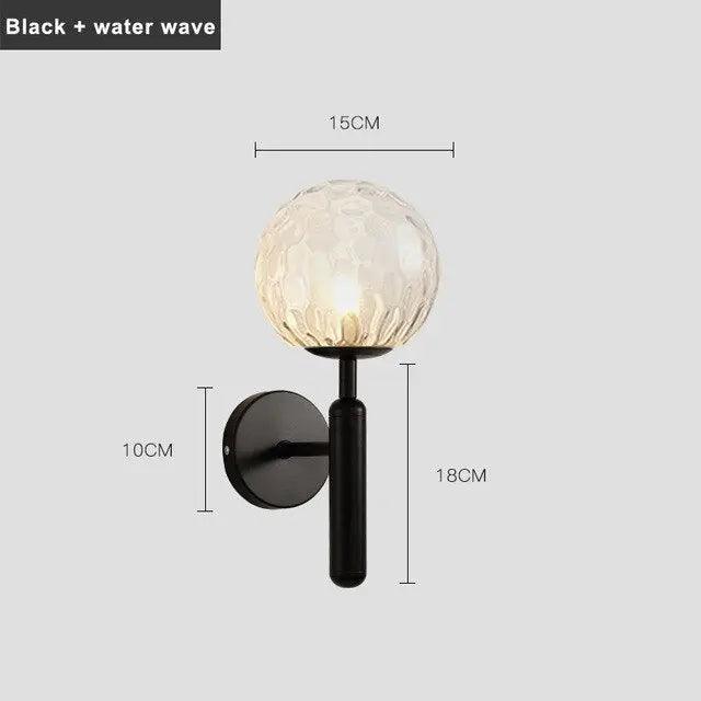 Mynte luxury gold wall sconce with marble base and milk glass shade in a bedroom