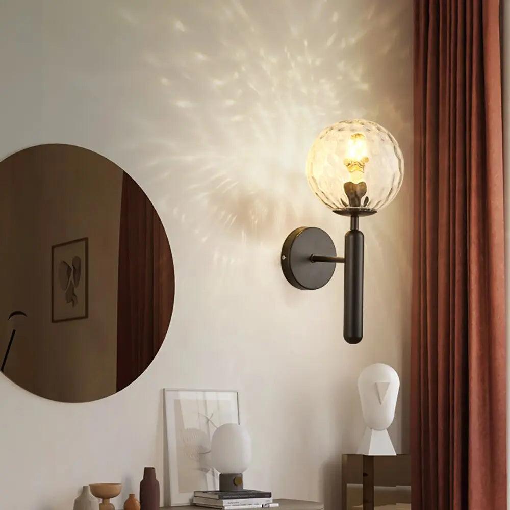 Mynte luxury gold wall sconce with marble base and milk glass shade in a bedroom