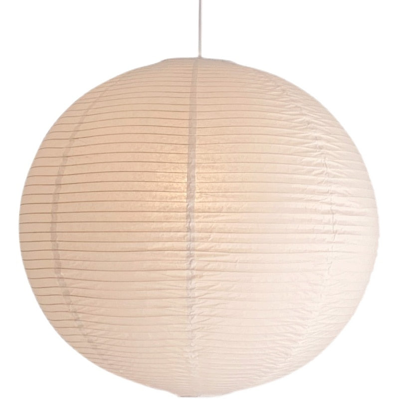 Linnea natural rattan pendant light hanging above a wooden dining table in a Nordic interior