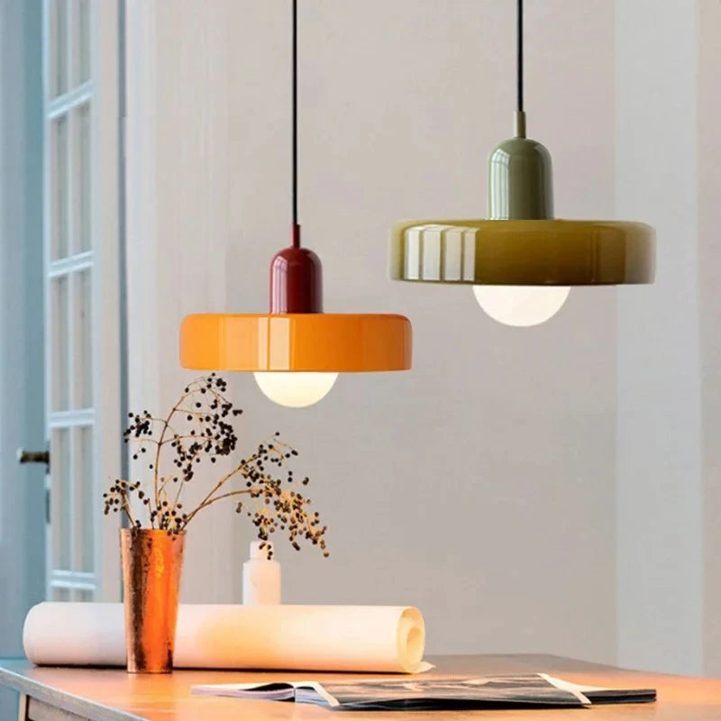 Bauhaus multi-pendant glass chandelier with orange shades hanging above a dining table in a café