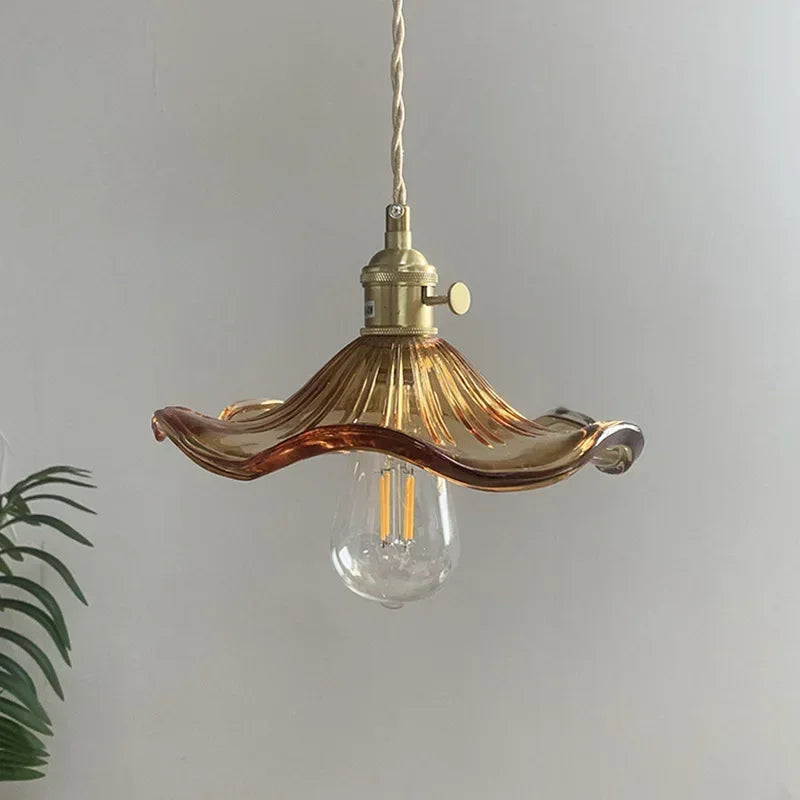 Prism green glass pendant light with copper fitting hanging in a dining room