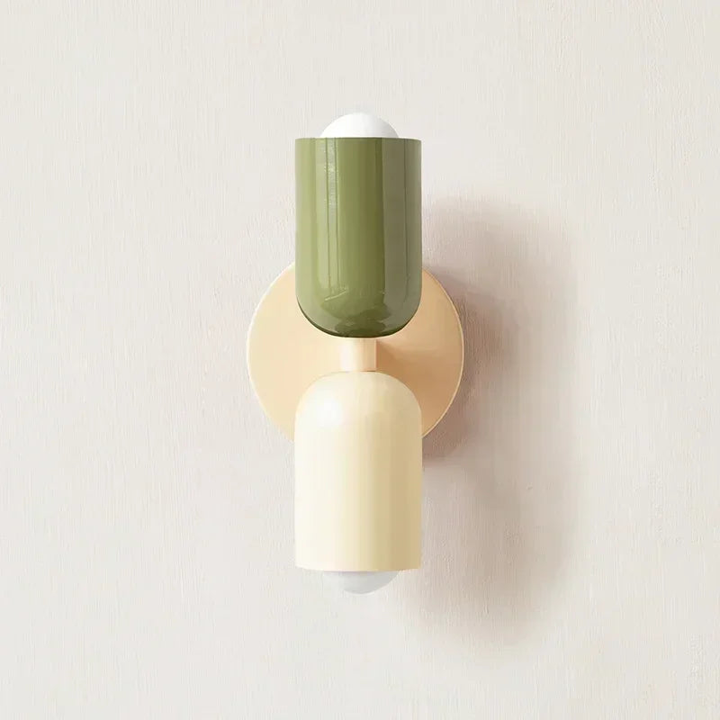 Macaron pastel pink wall lamp mounted in a children's bedroom beside a white bed