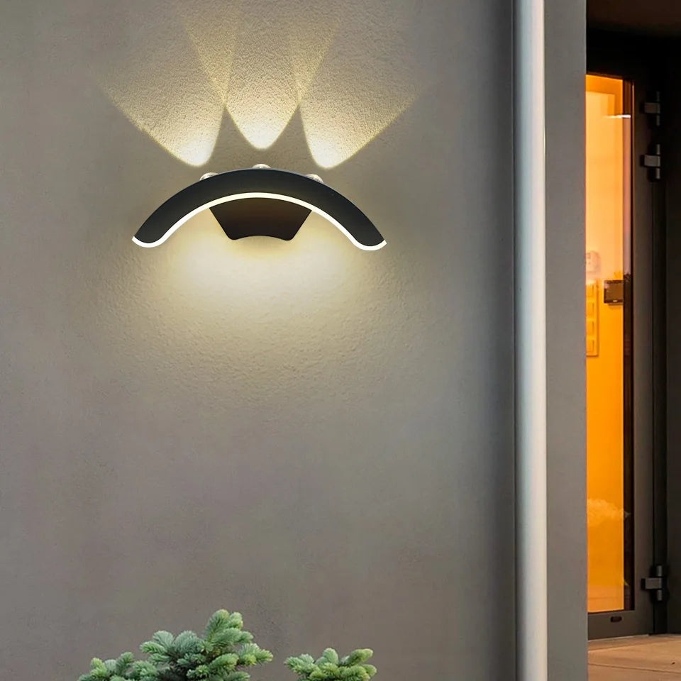 Hadley IP66 weatherproof outdoor wall lantern in black, mounted on a rendered exterior wall