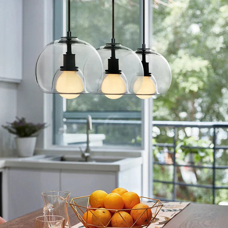 Anele smoke grey dome glass pendant light in a row of three above a kitchen island