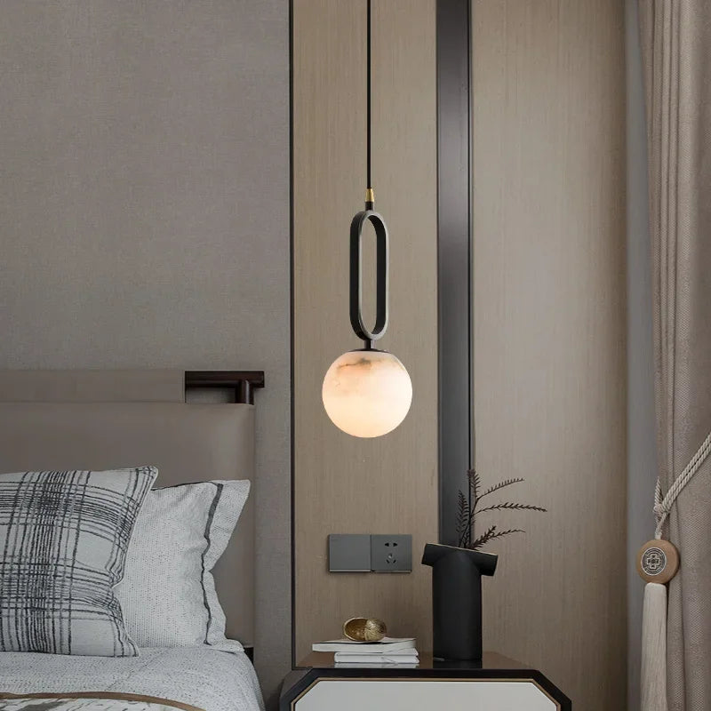 Hulda natural marble pendant light with copper accents above a formal dining table