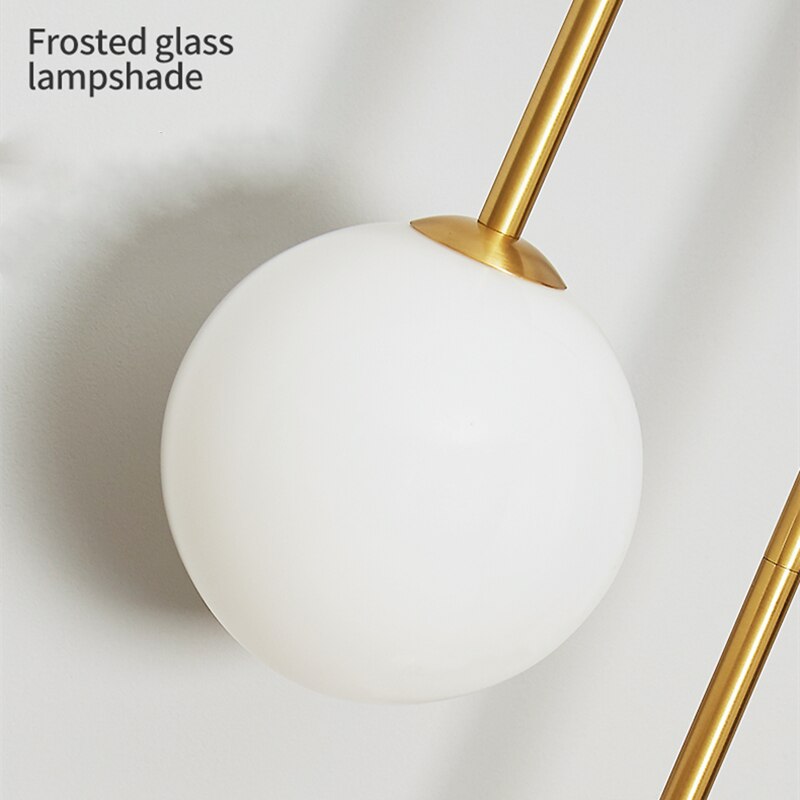 Amalia twin-arm gold Nordic wall sconce with white glass shades flanking a dining room mirror