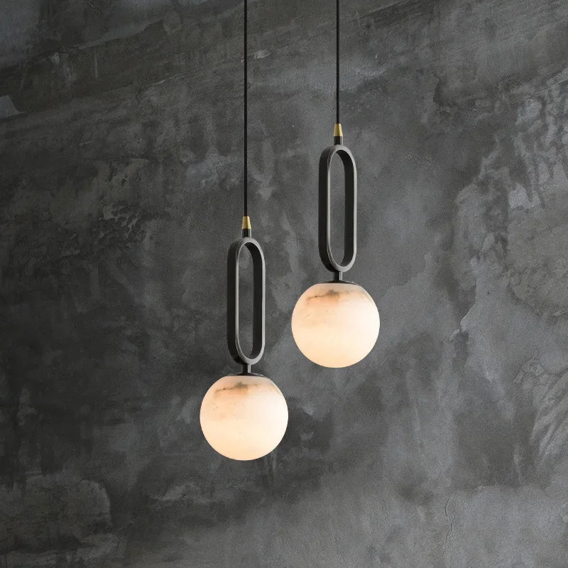 Hulda natural marble pendant light with copper accents above a formal dining table