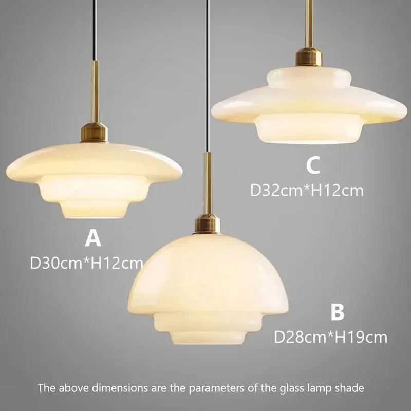 Opal milk glass pendant light hanging above a dining table, casting a soft warm glow