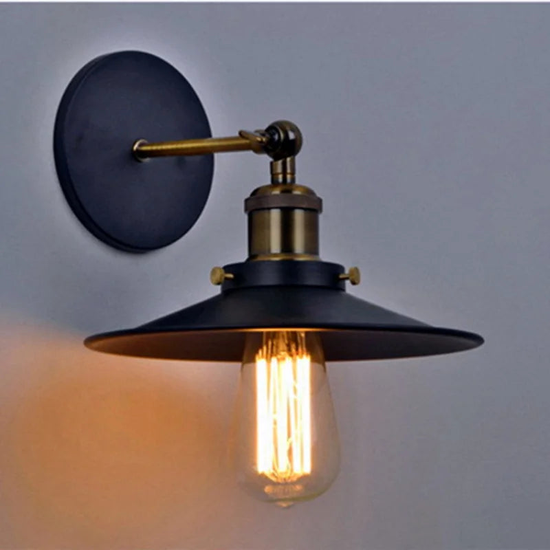 Edison industrial iron wall lamp in matte black mounted on a brick staircase wall