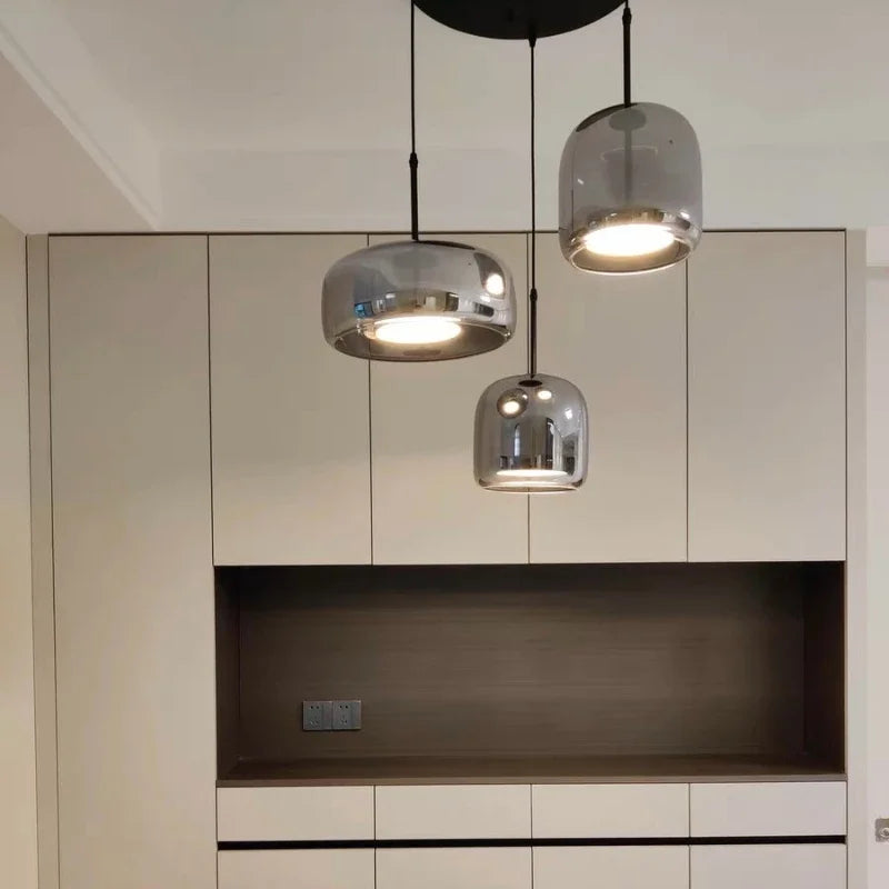 Astrid amber glass Nordic pendant light with gold fitting above a dining table