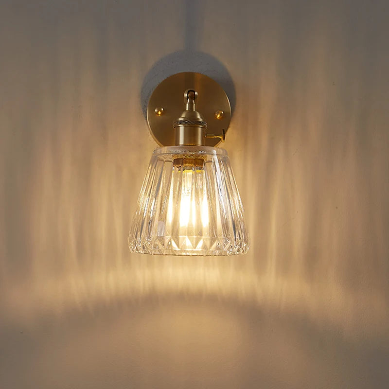 Kyoto brass and glass wall lamp mounted beside a bathroom mirror casting warm light