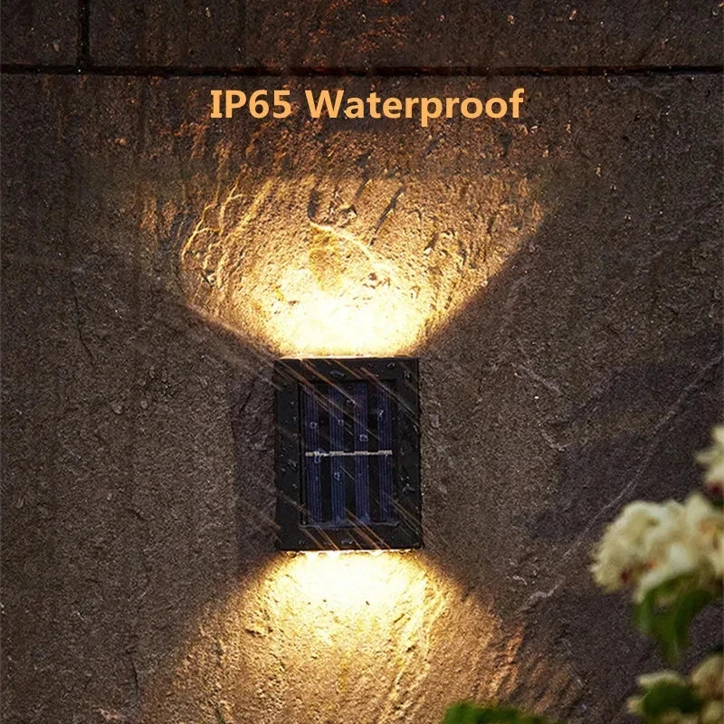 Solstice solar wall light mounted on a garden fence, illuminated at dusk