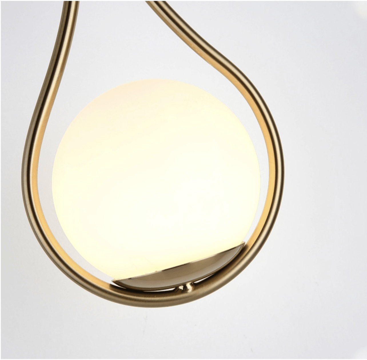 Livi gold Nordic wall sconce mounted beside a bed in a minimalist bedroom