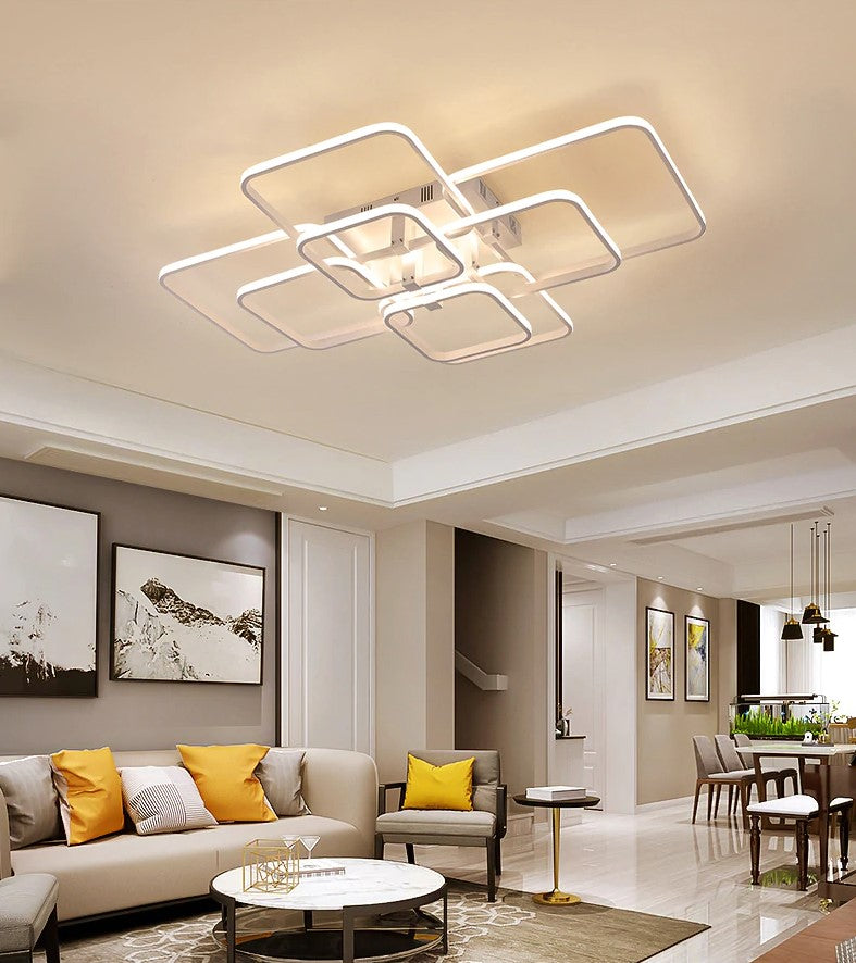 Quadrilateral geometric LED ring chandelier in white, illuminated in a living room with high ceilings