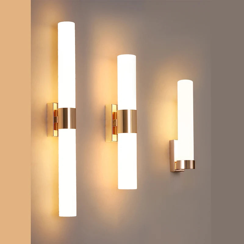 Harlow gold glass wall sconce with copper arm mounted in a living room beside an armchair