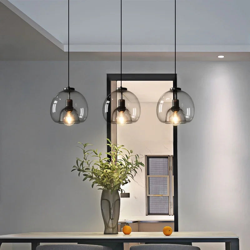 Anele smoke grey dome glass pendant light in a row of three above a kitchen island