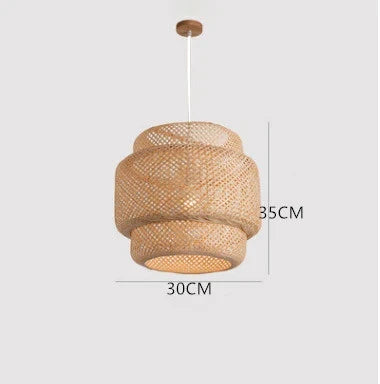 Wren handcrafted woven bamboo pendant light hanging above a wooden dining table in a warm interior