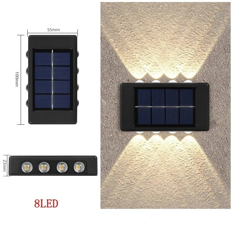 Solstice solar wall light mounted on a garden fence, illuminated at dusk
