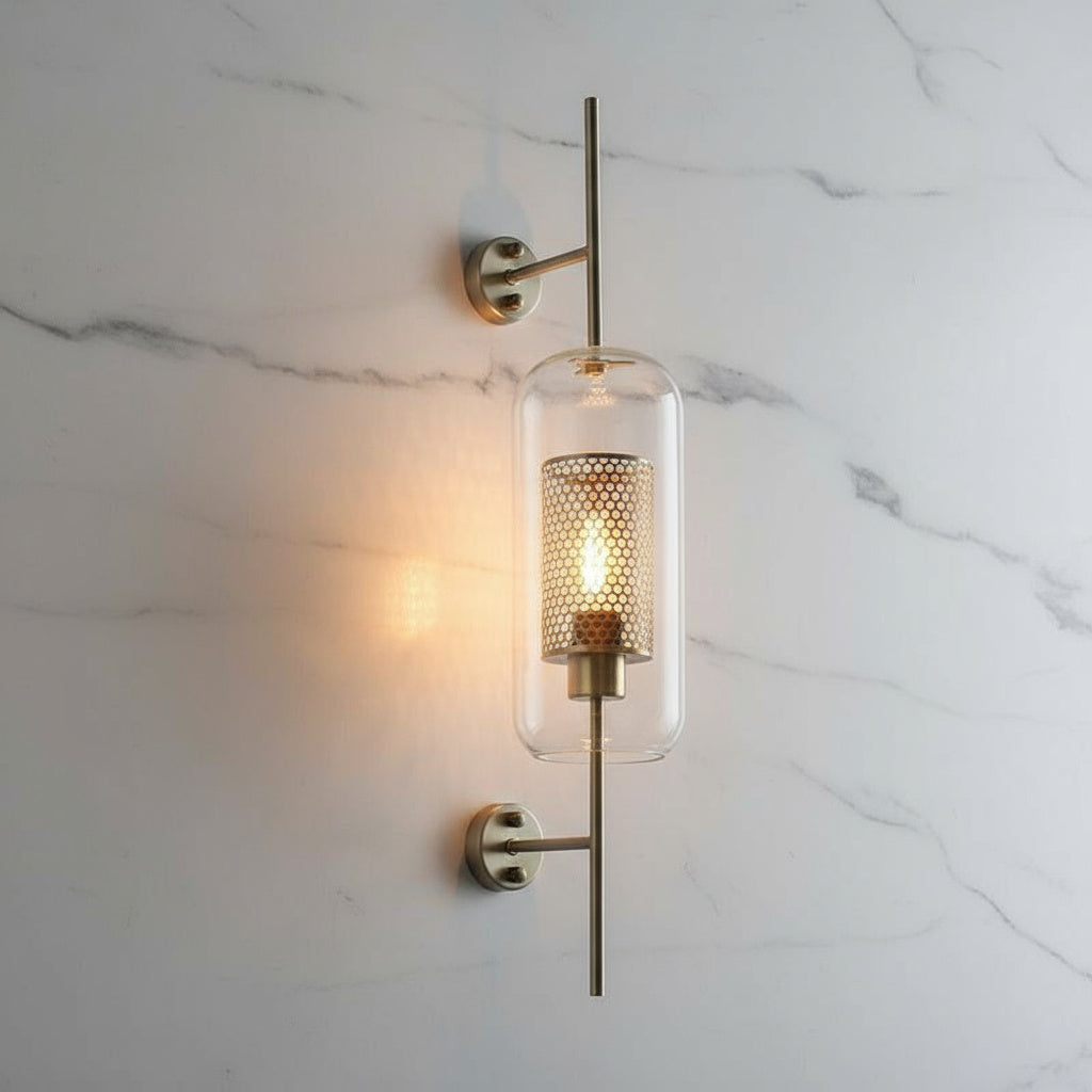 Alegria gold glass wall sconce flanking a bathroom mirror, casting warm light