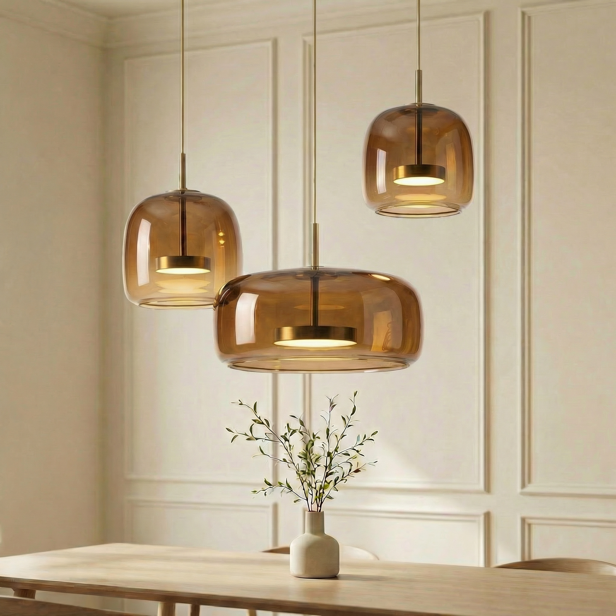 Astrid amber glass Nordic pendant light with gold fitting above a dining table