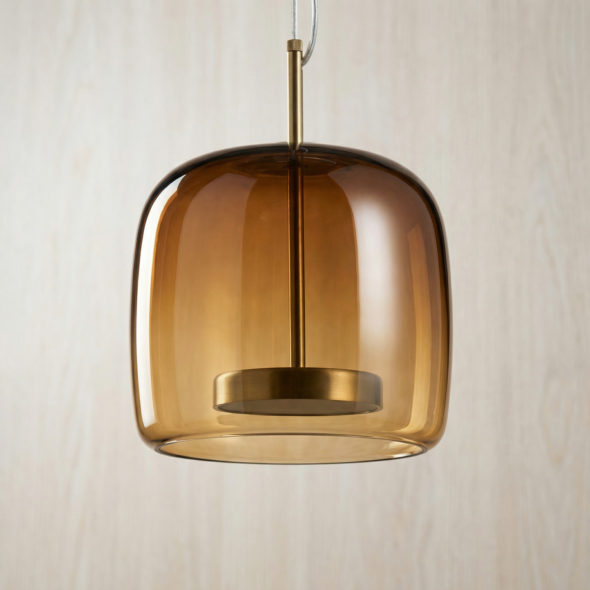 Astrid amber glass Nordic pendant light with gold fitting above a dining table