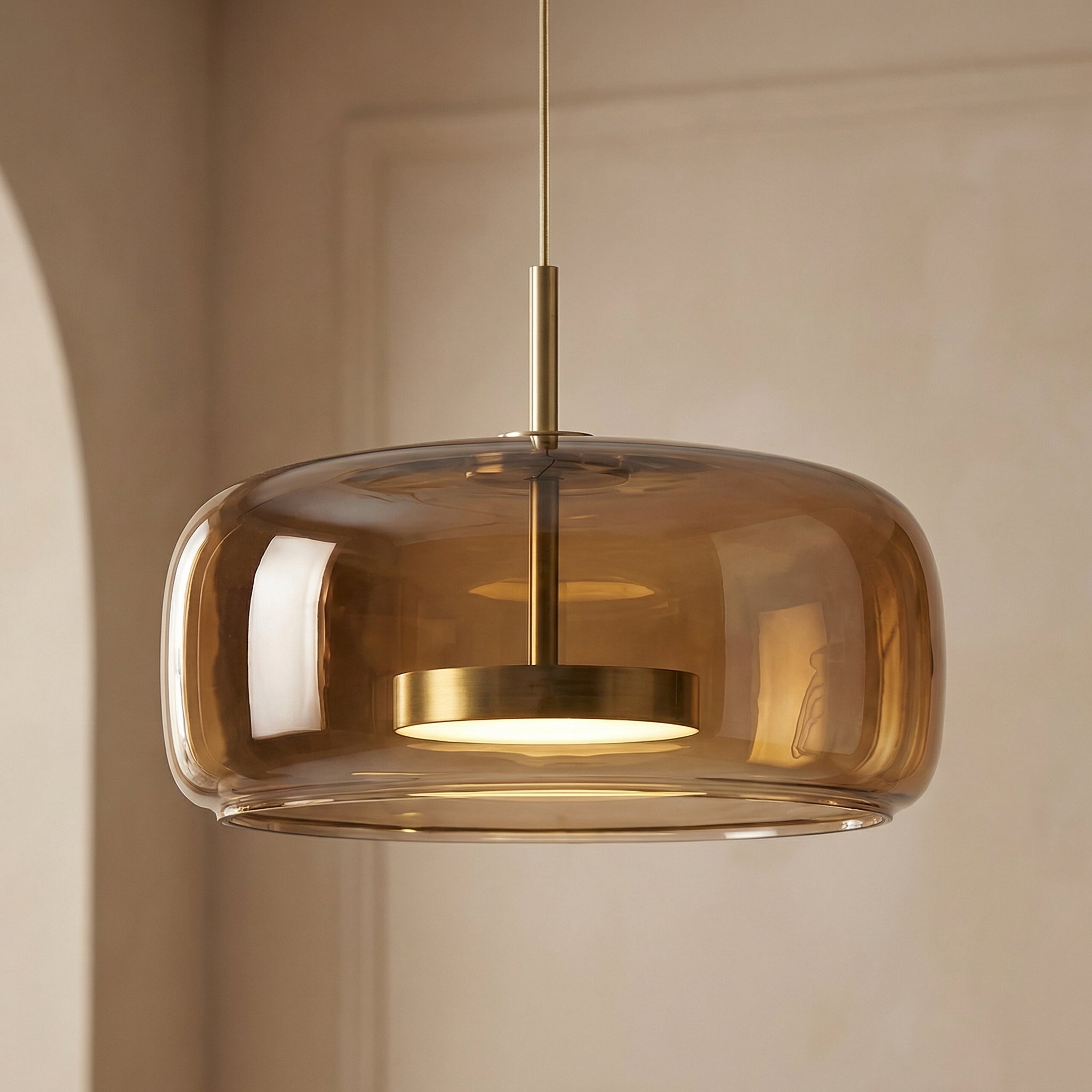 Astrid amber glass Nordic pendant light with gold fitting above a dining table