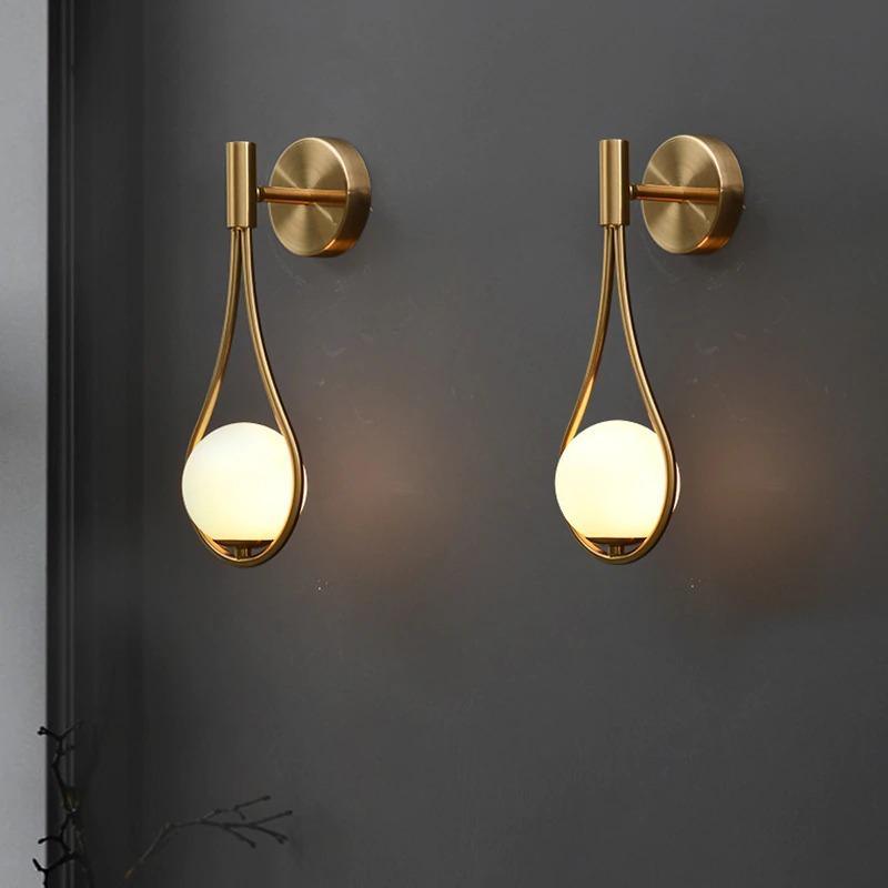 Livi gold Nordic wall sconce mounted beside a bed in a minimalist bedroom