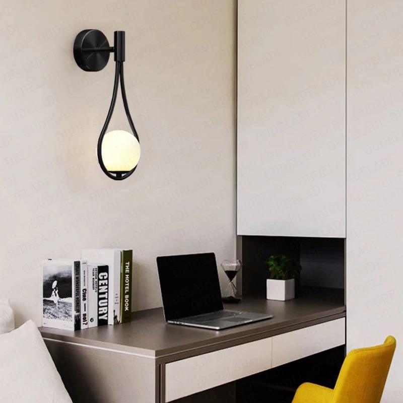 Livi gold Nordic wall sconce mounted beside a bed in a minimalist bedroom