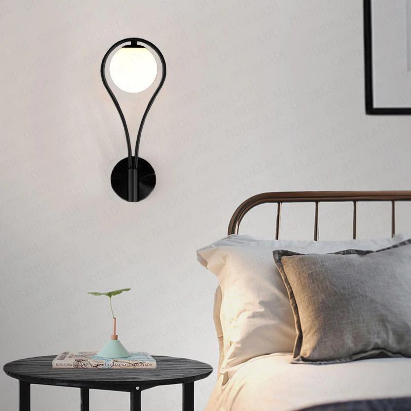 Livi gold Nordic wall sconce mounted beside a bed in a minimalist bedroom