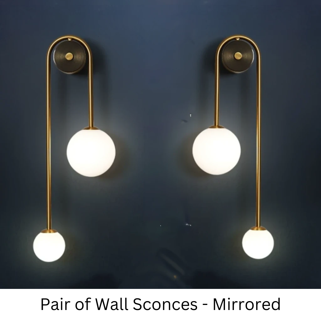 Amalia twin-arm gold Nordic wall sconce with white glass shades flanking a dining room mirror