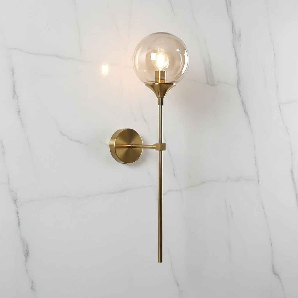 Annika amber glass ball wall sconce mounted in a dining room beside a mirror