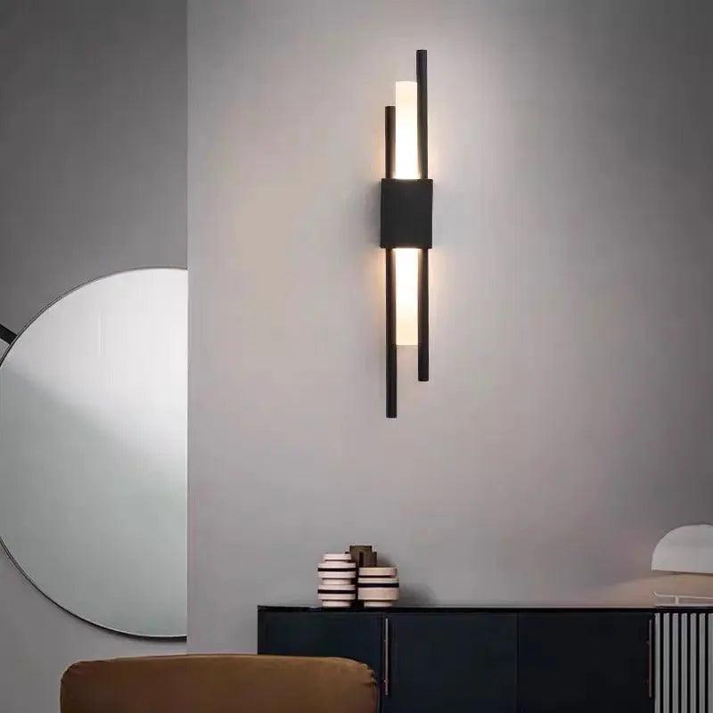Adan matte black articulated metal wall lamp mounted in a bedroom beside a headboard