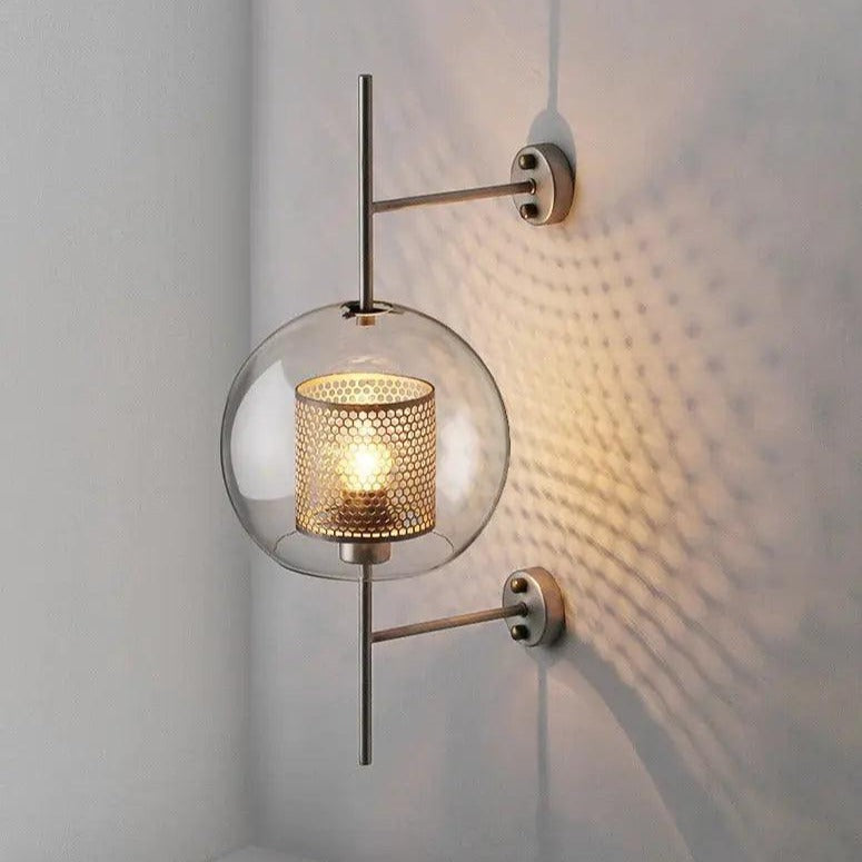 Alegria gold glass wall sconce flanking a bathroom mirror, casting warm light