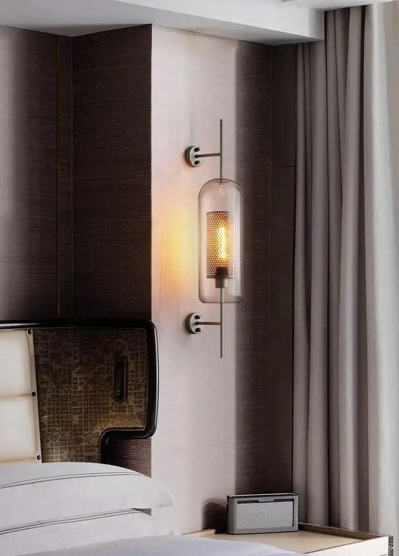 Alegria gold glass wall sconce flanking a bathroom mirror, casting warm light